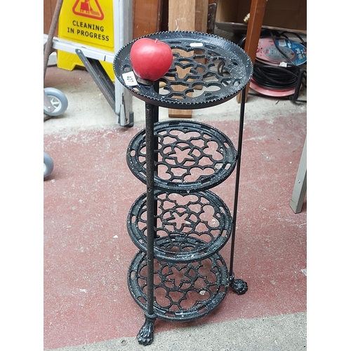 427 - A wonderful four tiered cast metal plant stand featuring pierced detail and claw feet.