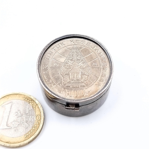 547 - A sterling silver ring dish set with an Indonesian bank coin lid, 3cm diameter, weight 19.21 grams.