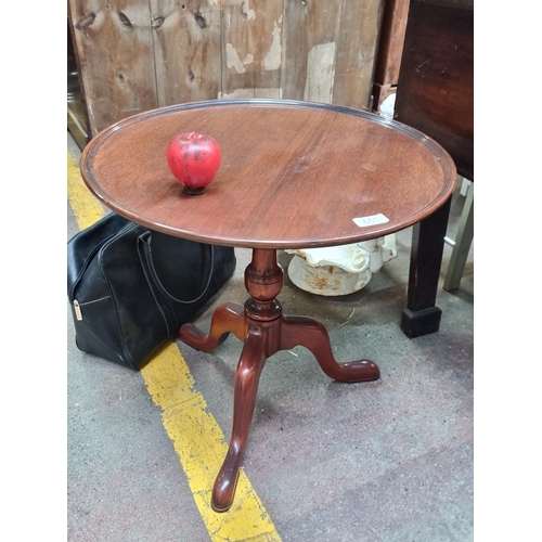 657 - A gorgeous vintage round table with lip to top, turned wood stem, held on a tripod base with cabriol... 