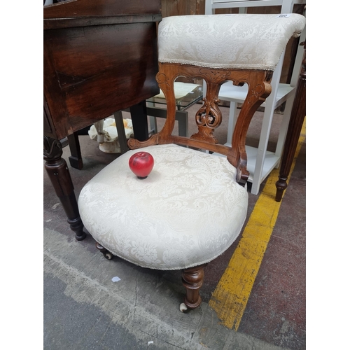 660 - Star Lot : A charming late Victorian nursing chair with wonderfully carved back boasting foliate mot... 