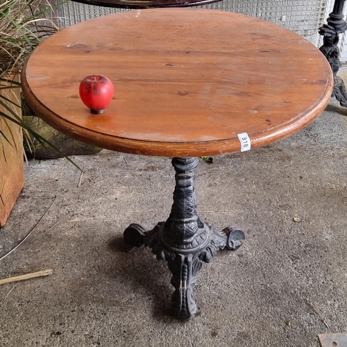 818 - A charming round cafe table with wooden top, held on a heavy antique cast metal base boasting fabulo... 