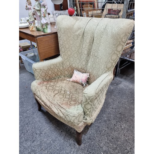 840 - A wingback armchair c. early 20th century, upholstered in a floral damask fabric. Includes a further... 