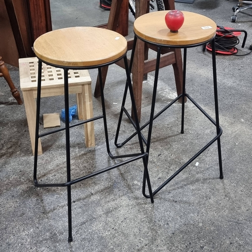 970 - Sleek mid-century modern bar stools featuring warm oak seats and sturdy black metal frames—ideal for... 