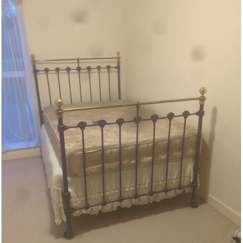 973 - Star Lot A Victorian-era cast iron bed frame, adorned with ornamental brass finials, a statement of ... 