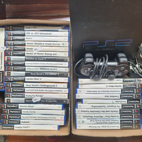 711 - Three boxes containing a PlayStation 2 console and a very selection of games including Buzz.