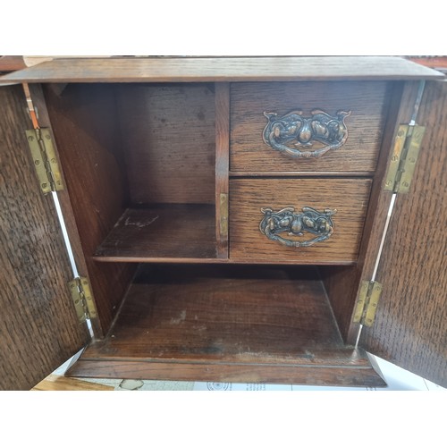 126 - A handsome oak smokers cabinet with lovely ornate hardware and brass hinges.