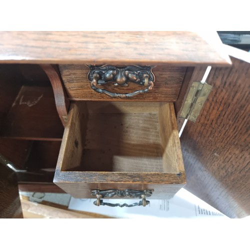 126 - A handsome oak smokers cabinet with lovely ornate hardware and brass hinges.