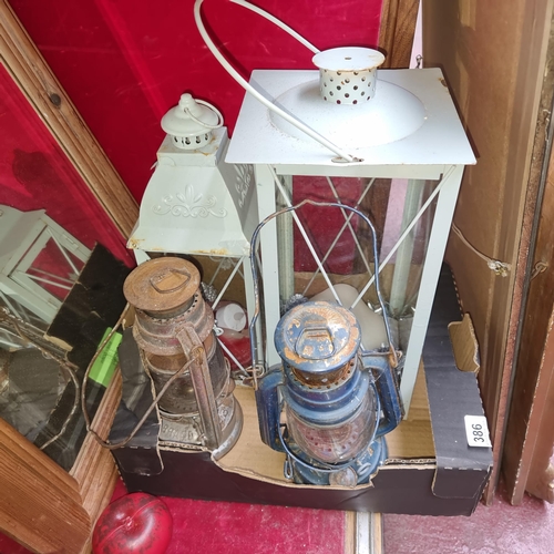 386 - Four vintage lanterns including 2 oil lamps and 2 metal candle lanterns.