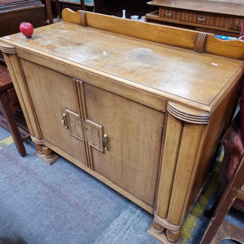 A magnificent large Art Deco Light oak sideboard featuring double doors to front sporting geometric motifs and a gallery back. 122cm W, 110cm T and 46cm D