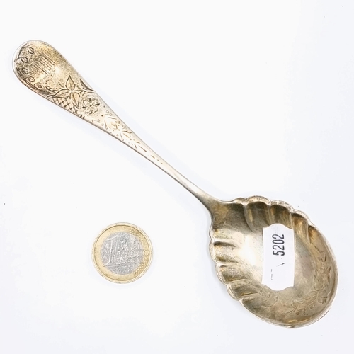 579 - A sterling silver preserve spoon with intricate detailing to bowl together with bright cut detailing... 