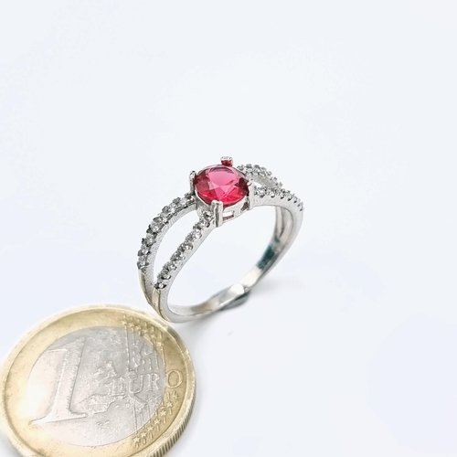 587 - A Sterling Silver red stone ring with white sapphire mount. Ring size - O. Weight 2.68 grams.