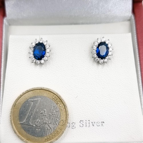 589 - A pair of 925  blue stone stud earrings with white sapphire surround. Old New Stock.