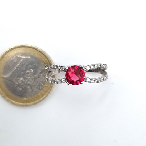 587 - A Sterling Silver red stone ring with white sapphire mount. Ring size - O. Weight 2.68 grams.