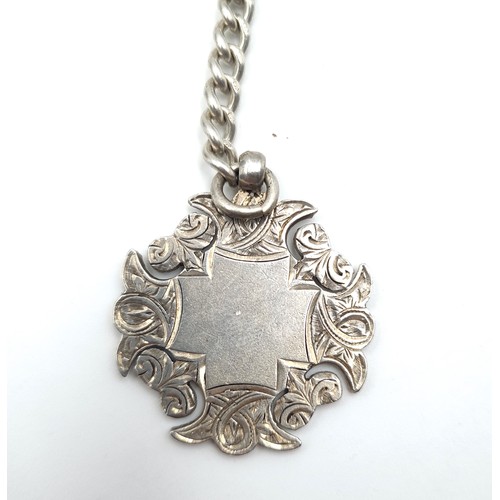 588 - An Edwardian sterling silver Albert chain with a finely decorated medallion plank to reverse. Hallma... 