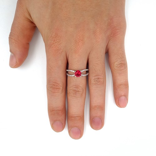 587 - A Sterling Silver red stone ring with white sapphire mount. Ring size - O. Weight 2.68 grams.