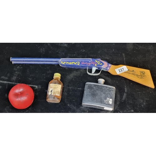 227 - A fabulous 1950's tin toy hunting rifle along with a Black & White whisky branded hip flask and a mi... 