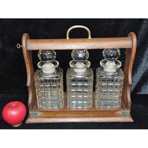 236 - A fabulous antique walnut tantalus containing three matching cut glass decanter with correct stopper... 