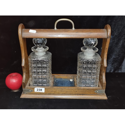 238 - A fabulous antique walnut tantalus containing two cut glass decanters. In very good condition.