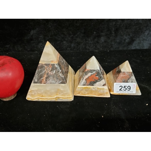 259 - A trio of heavy graduated marble pyramid ornaments.