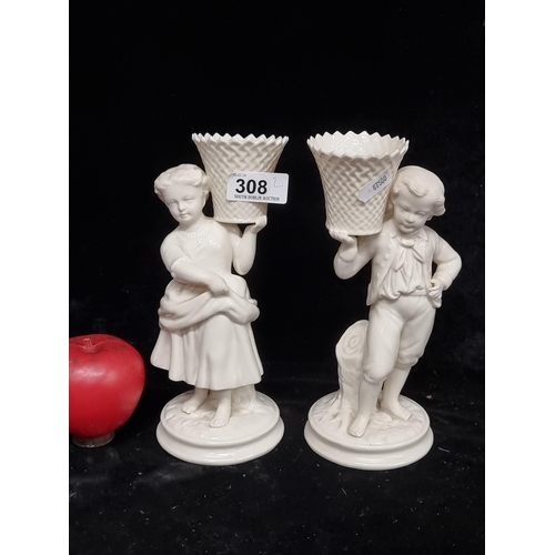 308 - A marvelous pair of Belleek candleholder  holder figurines depicting a young male and female holding... 