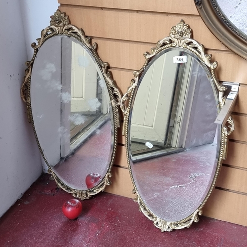 384 - A stunning pair of handsome vintage beveled mercury wall mirrors, held in gilt frames with lavish sc... 