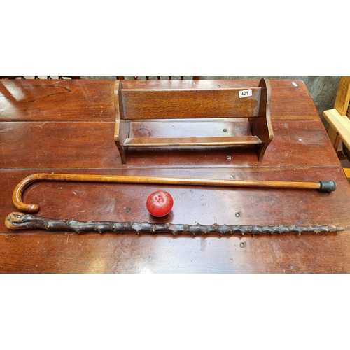 421 - A free standing wooden vintage  book trough along with a vintage Blackthorn walking stick and a wood... 