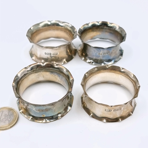 518 - A set of four Irish silver napkin rings with pie crust rim detailing. Weight - 57.29 grams.