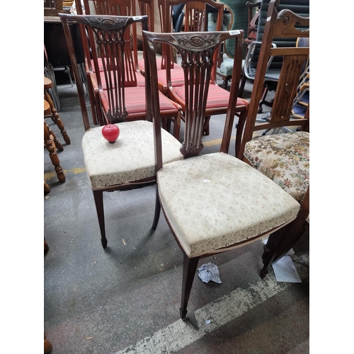 1011 - A pair of Edwardian occasional  chairs, mahogany with intricate carved backs, and upholstered seats.... 