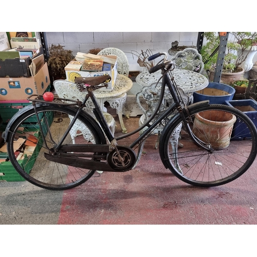 933 - Star Lot: A whimsical vintage high nelly Brooks bicycle, complete with metal frame and worn leather ... 