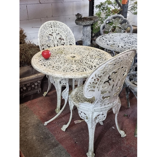 937 - Star Lot: An ornate garden set consisting of two chairs and a table, showcasing profuse scroll and f... 