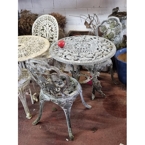 938 - Star Lot: An ornate garden set consisting of two chairs and a table, showcasing profuse scroll and f... 