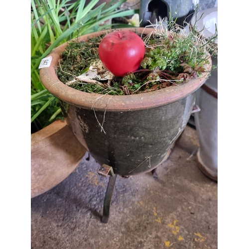 947 - A charming terracotta planter, held on cast metal tripod legs.