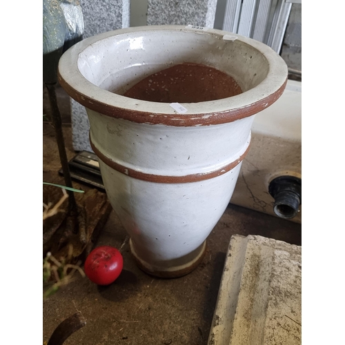 949 - A large ceramic terracotta planter, exhibiting a cream glaze with a contrasting rim design. A fetchi... 