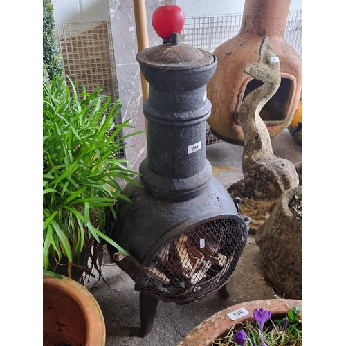 964 - A vintage cast iron outdoor fireplace chiminea. The epitome of rustic charm and functionality in you... 