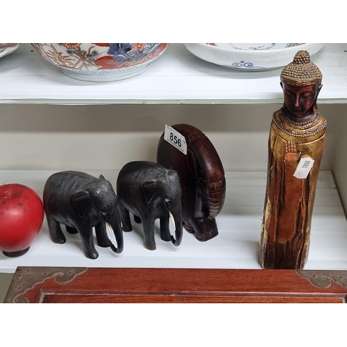 856 - Four characterful wooden figurines including three adorable elephants and a Buddha.