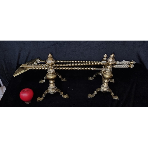 918 - A gorgeous pair of brass fire dogs along with three matching brass fireside tools including a tongs,... 