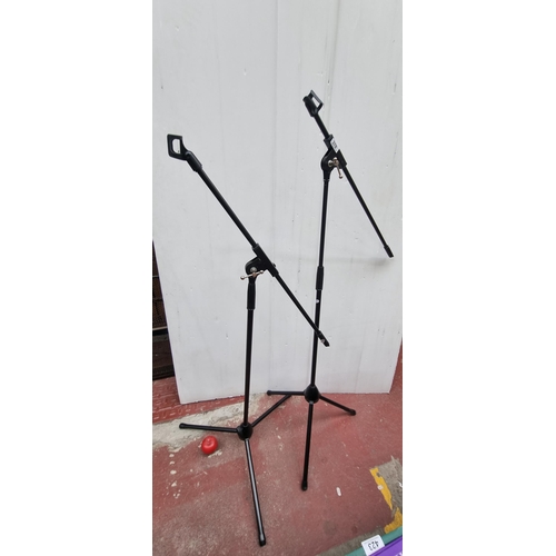 378 - A pair of adjustable black microphone stands, ideal for musicians and sound engineers.