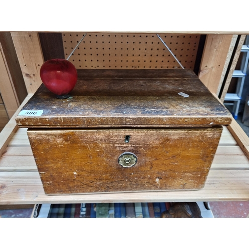 386 - An antique oak storage box with brass handle, exuding antique charm and functional elegance.