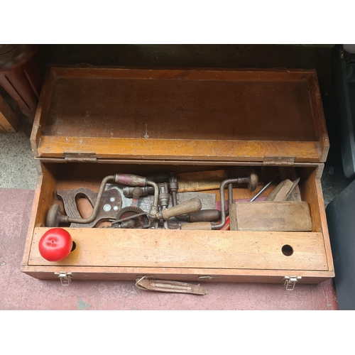 428 - A vintage wooden carpenters toolbox including an assorted collection of traditional hand tools.