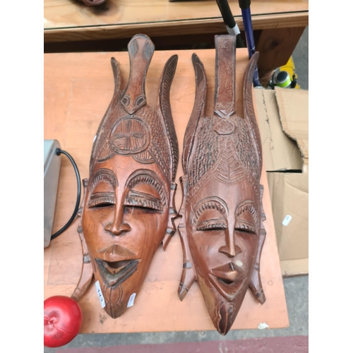 443 - Intricate African carved wooden masks, displaying detailed tribal patterns and rich patina. A profou... 