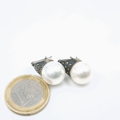 63 - A pair of sterling silver and marcasite faux pearl earrings suitable for pierced ears.