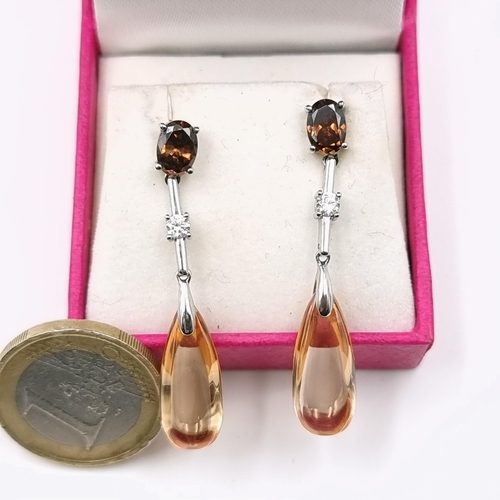 77 - A pretty pair of amber coloured drop pendant stud earrings set with gem set accents.