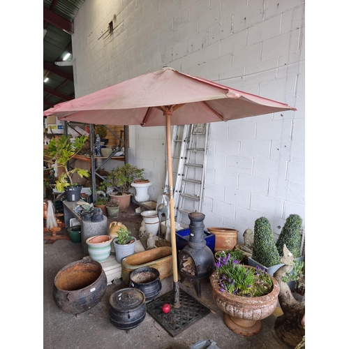 984 - A large  patio umbrella / parasol held onto a heavy cast iron base.