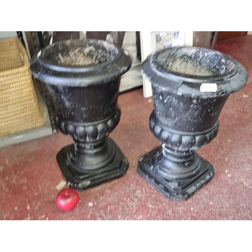 997 - Star Lot : Two elegant heavy black  urns / planters. Featuring classic gadrooning in a black painted... 