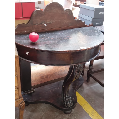 587 - Star Lot : A stunning Irish Georgian demi lune hall table held onto three supports one impressively ... 