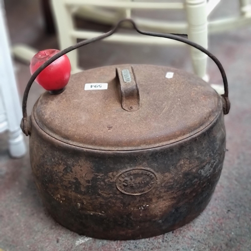 594 - A large antique lidded Kendrick Swing pot along with two hand irons.