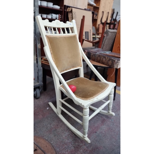 595 - A characterful vintage rocking chair upholstered with a mustard coloured seat and back support, fini... 