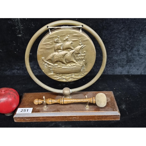 251 - A vintage brass dinner gong featuring ship design in relief.