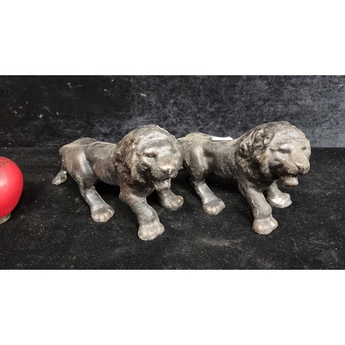 298 - A pair of heavy cast iron lion figures.