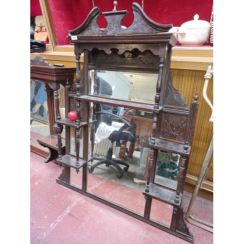 370 - A beautiful Victorian overmantel mirror featuring multiple shelves and bevelled mirrors with carved ... 